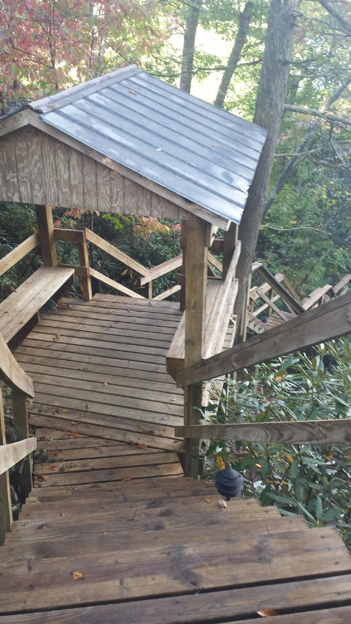 Metal roofed shelter over wooden steps on a wooded walkway — Skylight Repair & Installation work by our crew in Littleton